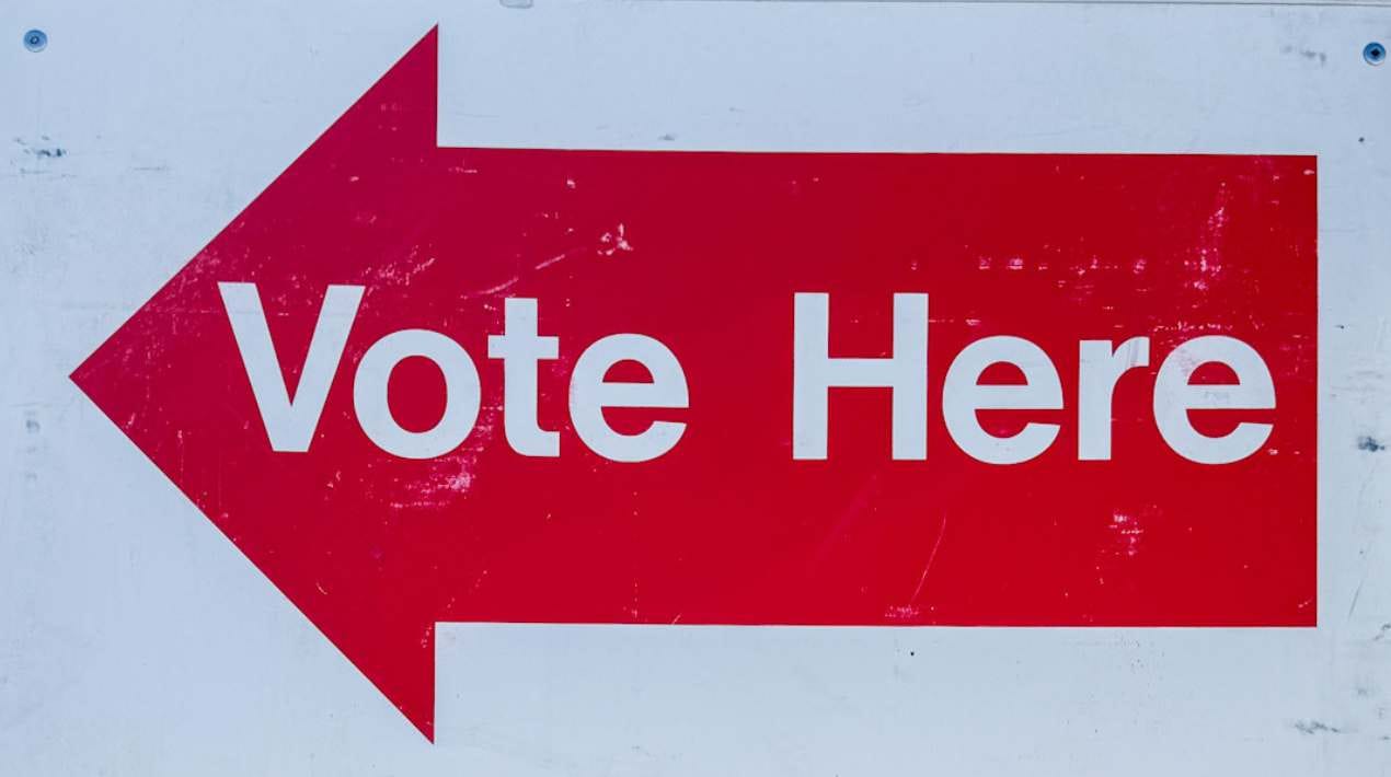 A "vote here" sign sits outside the Palmer Depot 