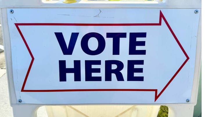 A "vote here" sign sits in front of Wasilla City Hall